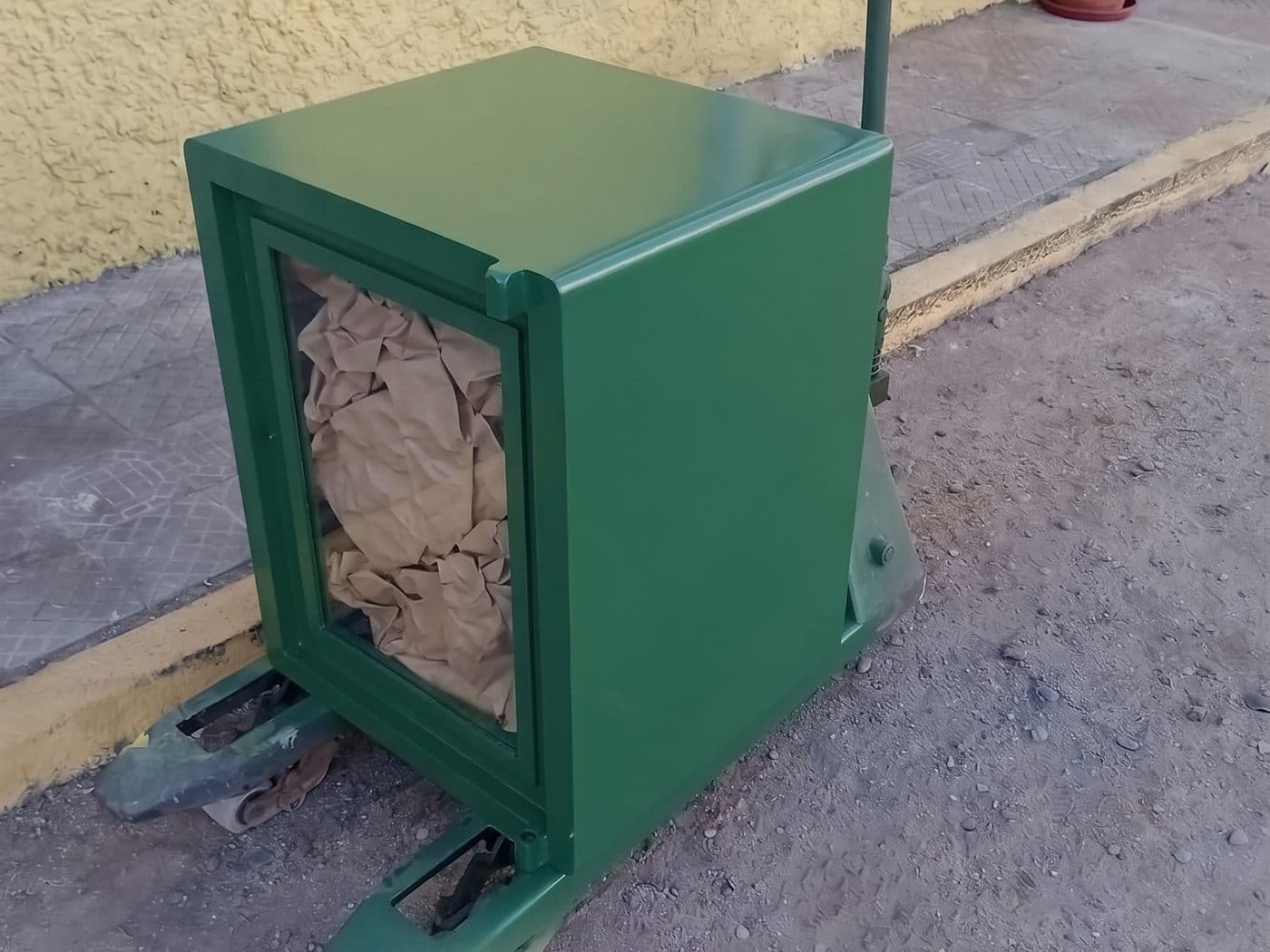 Caja fuerte sobre una transpaleta en la vereda, lista para cargarla al camión