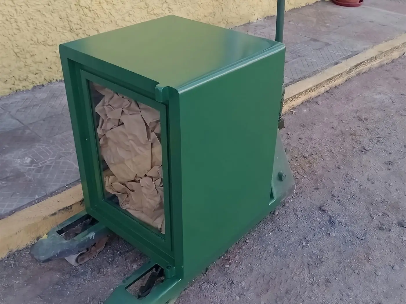 Caja fuerte sobre una transpaleta en la vereda, lista para cargarla al camión